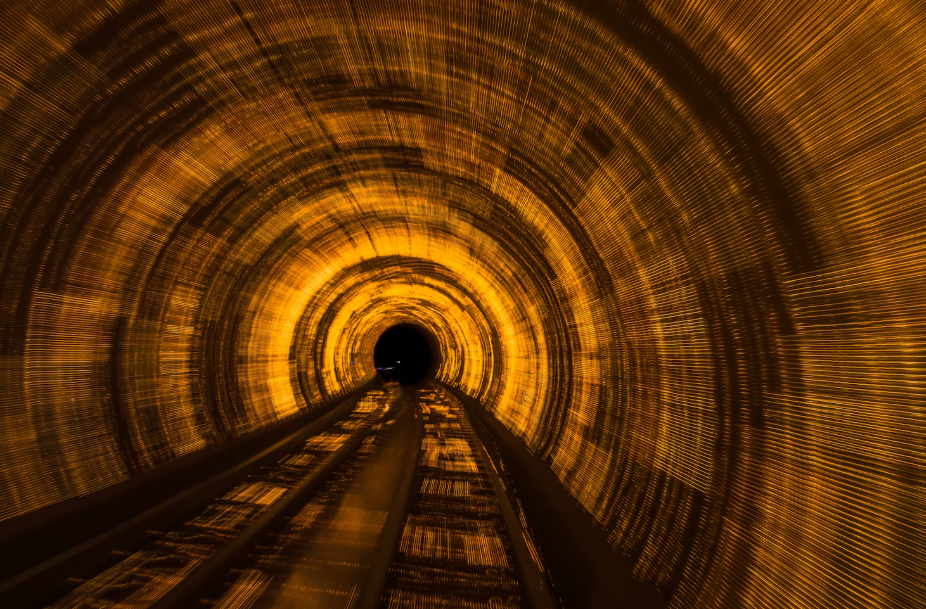 Long-exposure shot inside a glowing gold tunnel with motion blur, visualizing the gravity tunnel concept