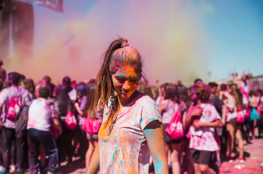 Young woman covered in bright powders at a Holi celebration in India