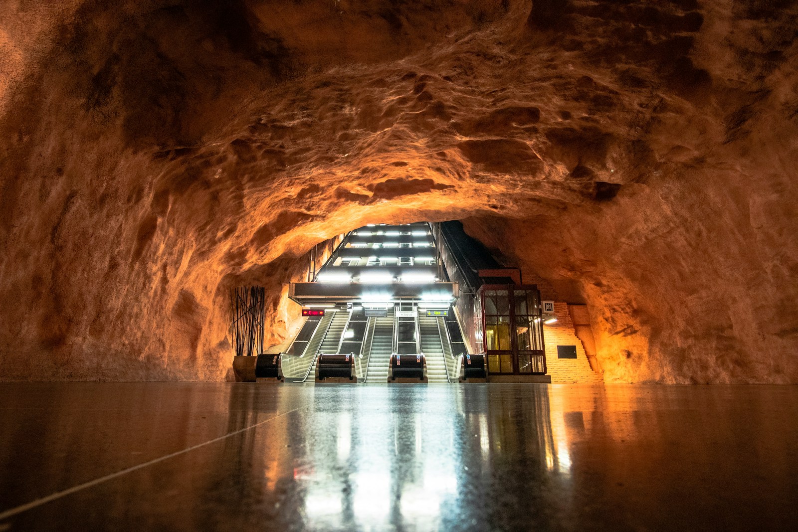 grey escalator inside brown cave